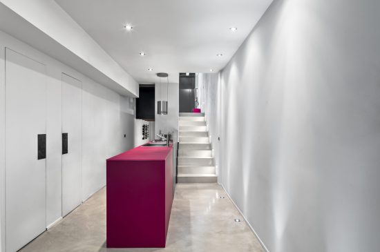 modern interior kitchen in the foreground the island kitchen with integrated sink in the background on the right the masonry staircase leading to the entranceentrance